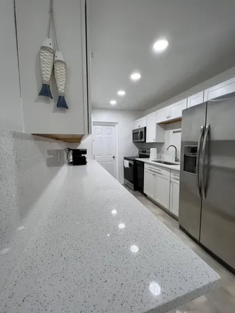 a kitchen with stainless steel appliances a refrigerator sink and microwave