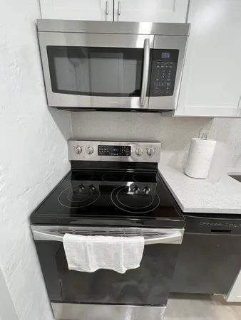 a large kitchen with stainless steel appliances granite countertop a sink a stove and a refrigerator