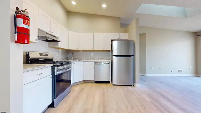 a kitchen with stainless steel appliances granite countertop a refrigerator sink and stove