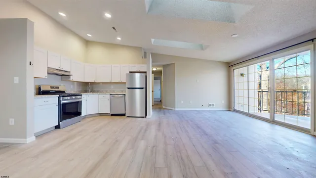 a view of kitchen with wooden floor and electronic appliances