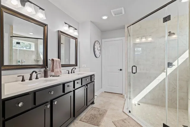 a bathroom with a double vanity sink mirror double and shower