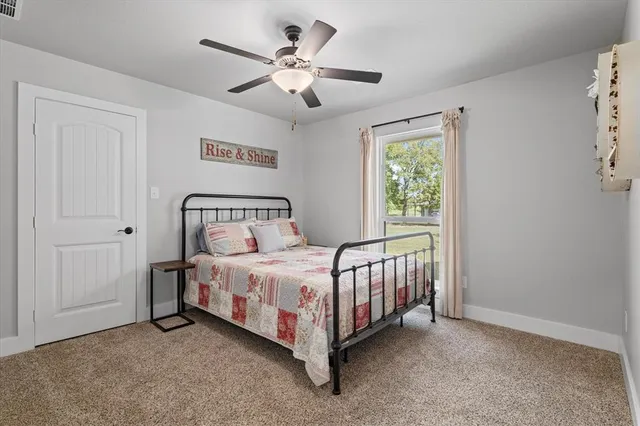 a bedroom with a bed and a ceiling fan