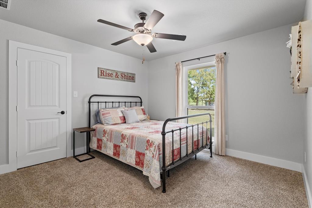 725 Wilson Road Van Alstyne, TX 75495 - Photo 17 of 40 a bedroom with a bed and a ceiling fan