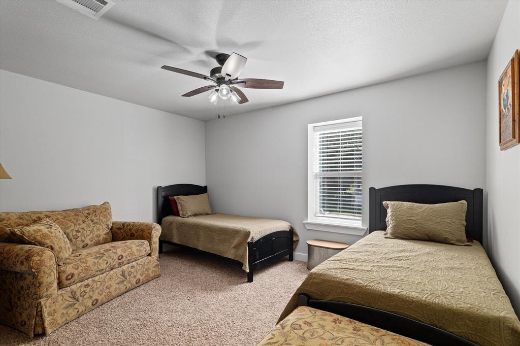 725 Wilson Road Van Alstyne, TX 75495 - Photo 25 of 40 a bedroom with two beds and ceiling fan