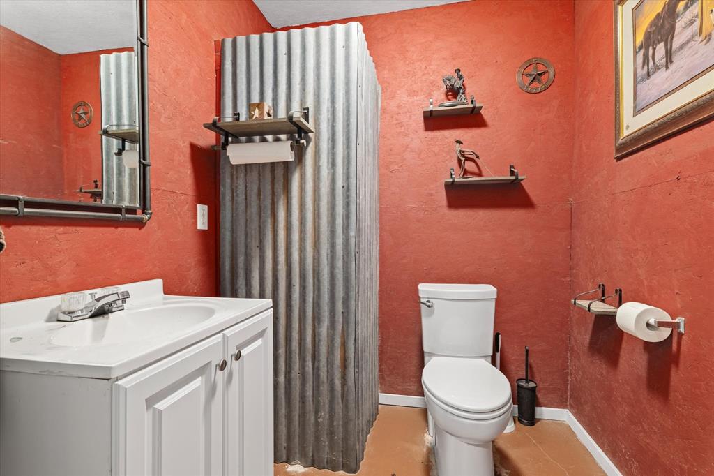 725 Wilson Road Van Alstyne, TX 75495 - Photo 31 of 40 a bathroom with a sink a toilet and a mirror