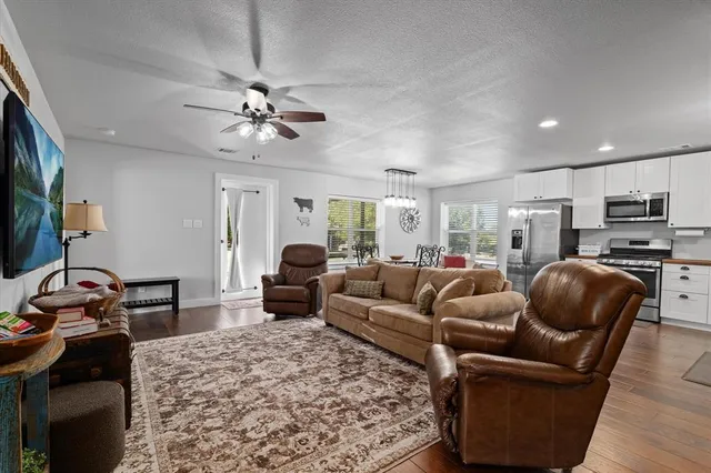 a living room with furniture a flat screen tv and kitchen view