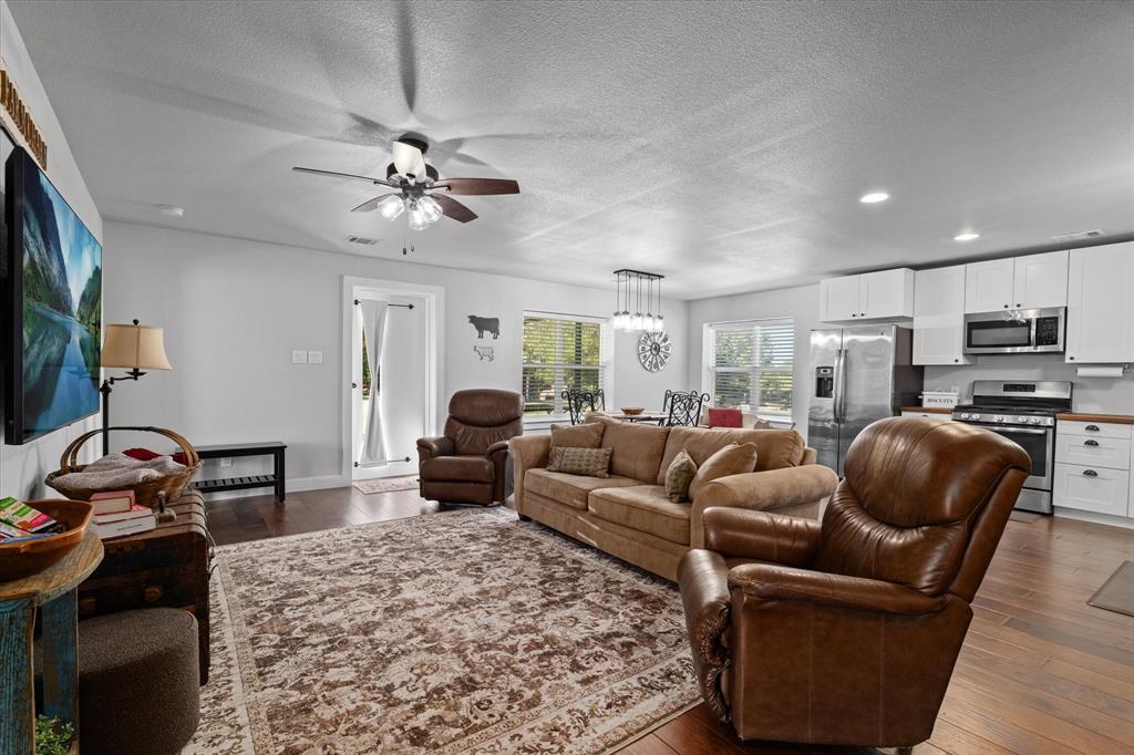 725 Wilson Road Van Alstyne, TX 75495 - Photo 9 of 40 a living room with furniture a flat screen tv and kitchen view