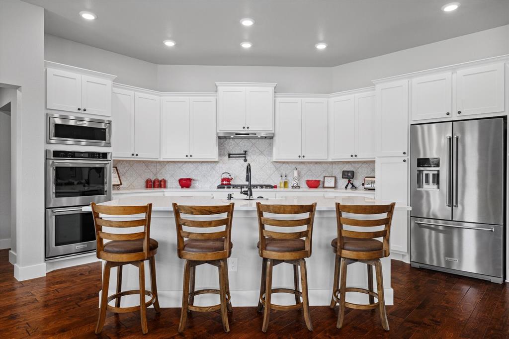 725 Wilson Road Van Alstyne, TX 75495 - Photo 10 of 40 a kitchen with stainless steel appliances granite countertop a dining table chairs refrigerator and cabinets