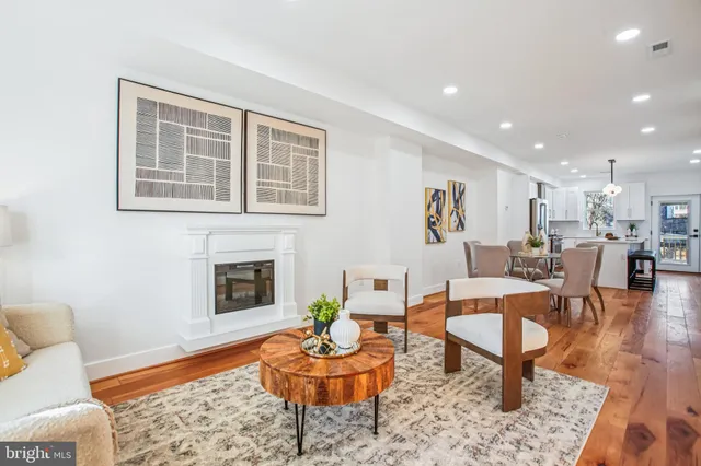 a living room with furniture a rug a fireplace and windows