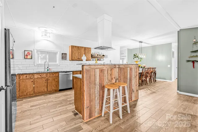 a kitchen with stainless steel appliances kitchen island granite countertop a table and chairs in it