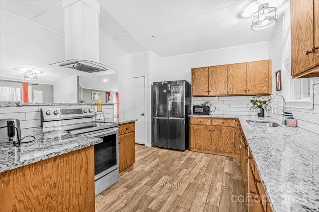 a kitchen with stainless steel appliances granite countertop a sink stove and refrigerator