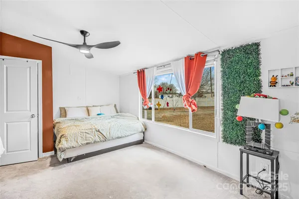 a bedroom with furniture and a large window