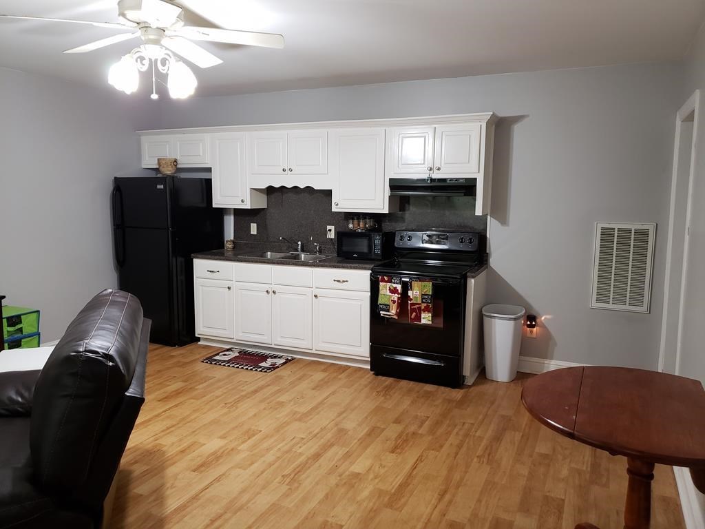 20 Lower Simmons Road Macon, GA 31220 - Photo 19 of 32 a kitchen with stainless steel appliances kitchen island granite countertop a refrigerator a stove top oven with a dining table and chairs