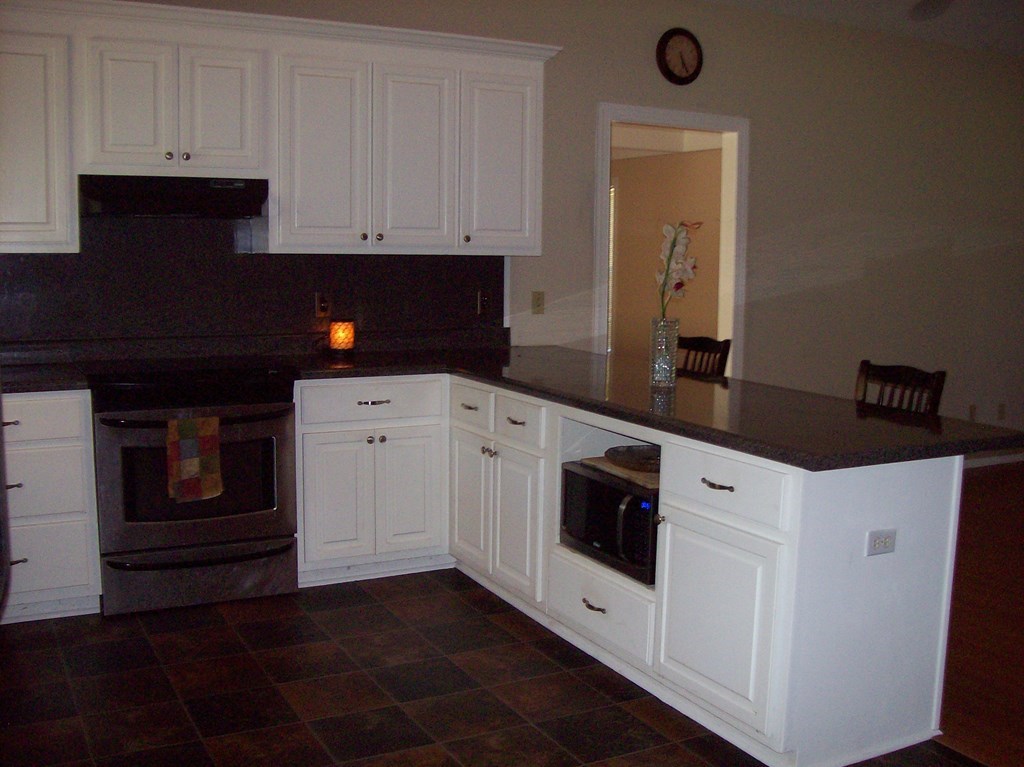 20 Lower Simmons Road Macon, GA 31220 - Photo 5 of 32 a kitchen with granite countertop white cabinets and black appliances