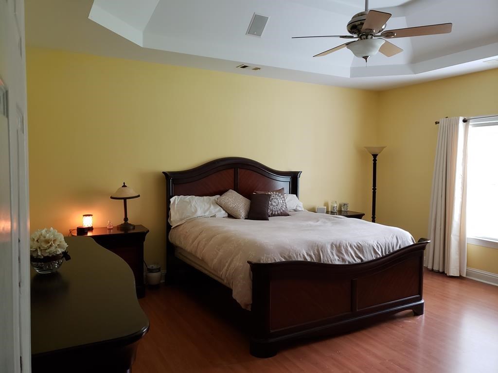 20 Lower Simmons Road Macon, GA 31220 - Photo 10 of 32 a large bed sitting in a room next to a lamp and a chandelier
