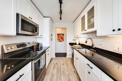 a kitchen with stainless steel appliances a sink stove top oven and microwave