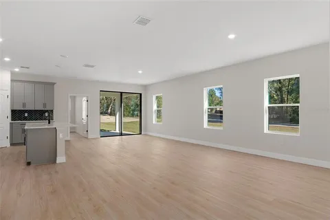 a view of kitchen with granite countertop stainless steel appliances refrigerator sink and cabinets