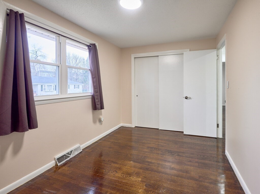 29 Dillon Street Worcester, MA 01604 - Photo 14 of 22 an empty room with wooden floor and windows