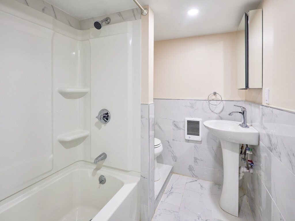 29 Dillon Street Worcester, MA 01604 - Photo 21 of 22 a bathroom with a bathtub sink vanity and mirror
