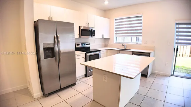 a kitchen with stainless steel appliances a refrigerator sink and microwave