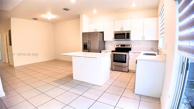a kitchen with a sink a stove top oven and stainless steel appliances