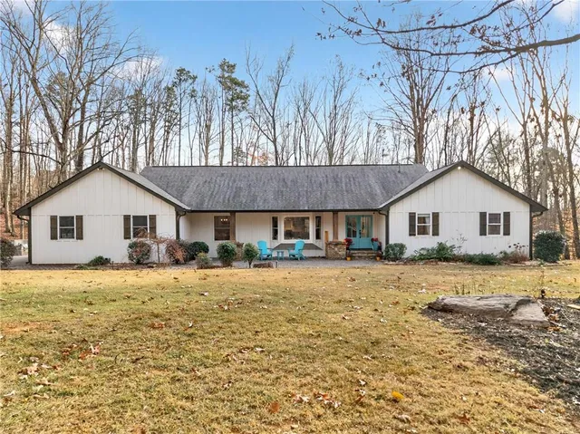 a front view of a house with a yard covered with snow in front of it