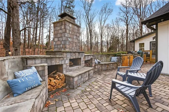 a view of a patio with couches table and chairs under an umbrella