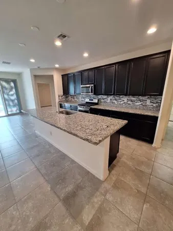 a kitchen with stainless steel appliances kitchen island granite countertop wooden cabinets a sink and dishwasher