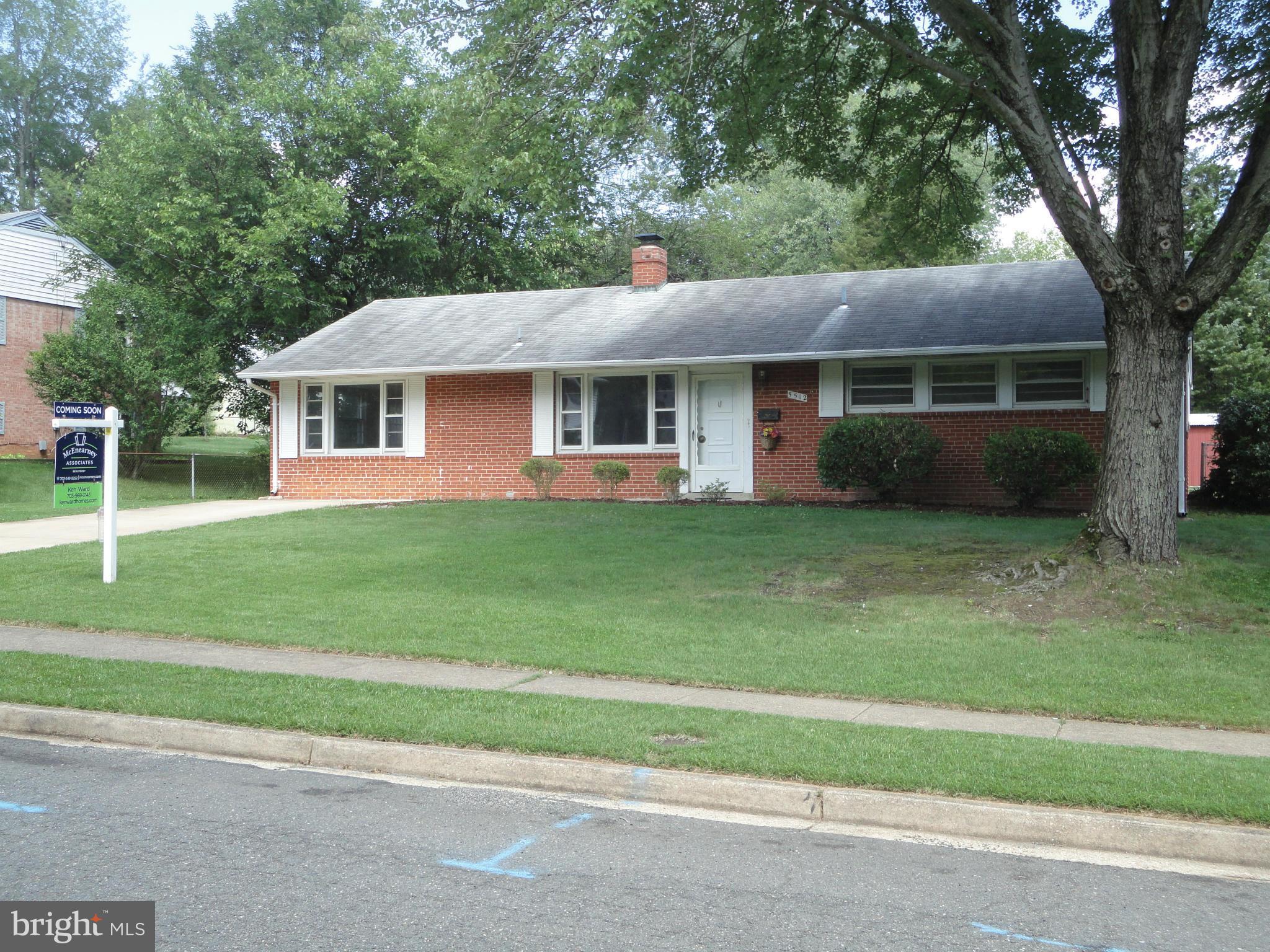 5512 Moultrie Road Springfield, VA 22151 - Photo 1 of 27 a front view of a house with a garden and trees