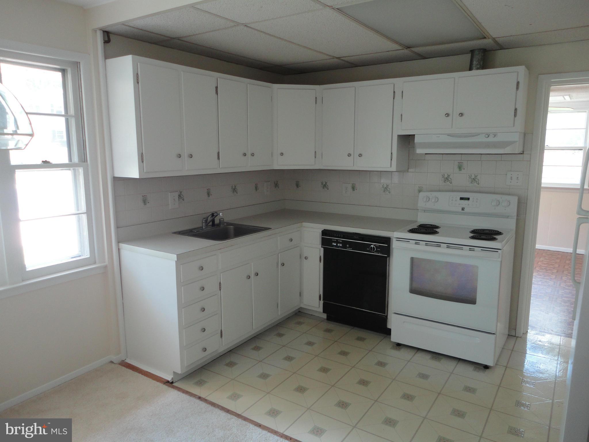 5512 Moultrie Road Springfield, VA 22151 - Photo 13 of 27 a kitchen with white cabinets and white appliances