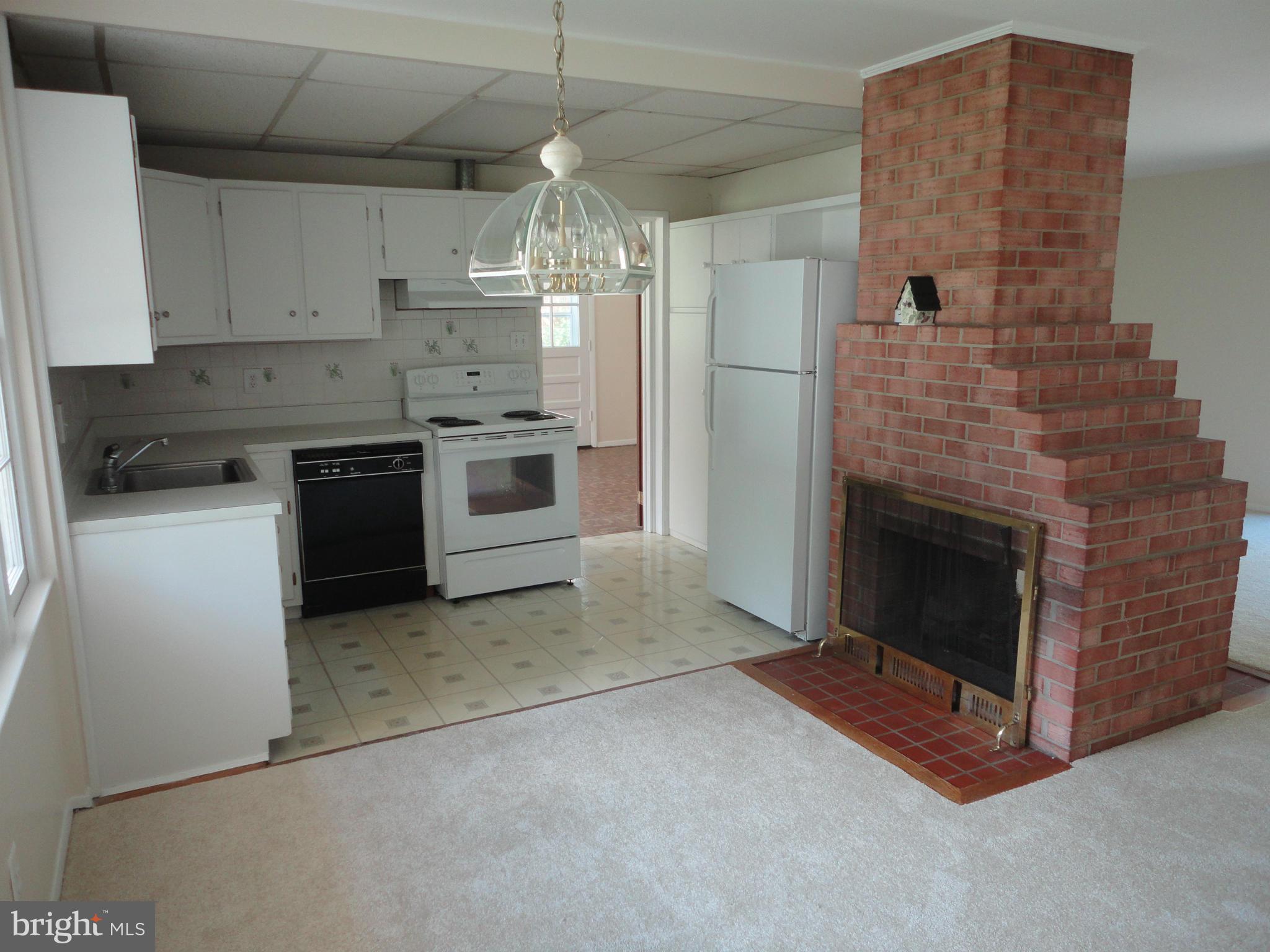 5512 Moultrie Road Springfield, VA 22151 - Photo 14 of 27 a kitchen with stainless steel appliances granite countertop a stove a refrigerator and a fireplace