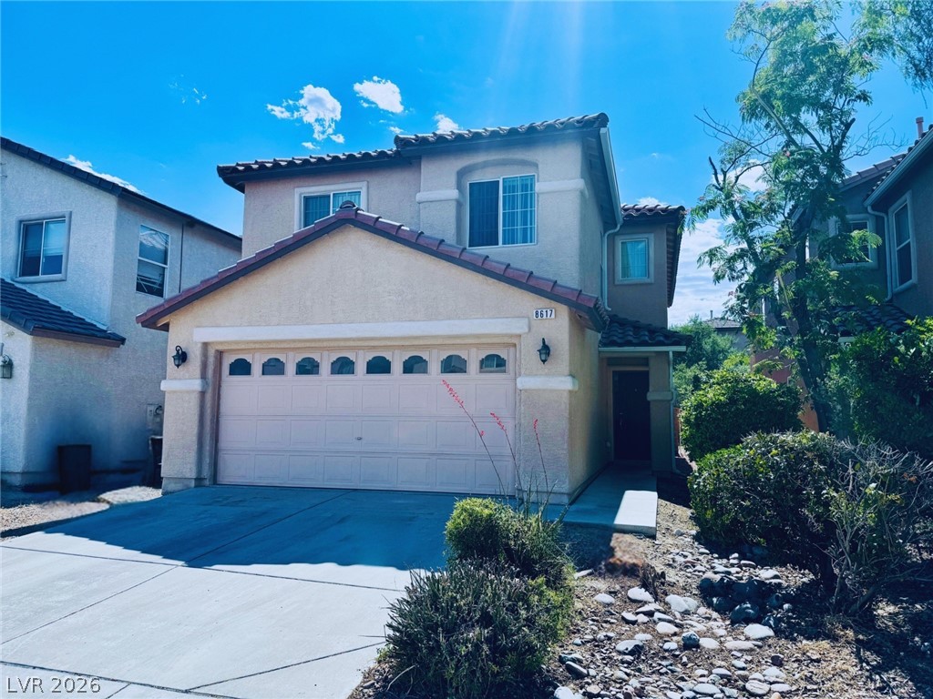 8617 Palomino Ranch Street Las Vegas, NV 89131 - Photo 1 of 27 An inviting exterior with a tan facade and a two-car garage awaits.