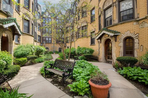a front view of a house with a yard and potted plants