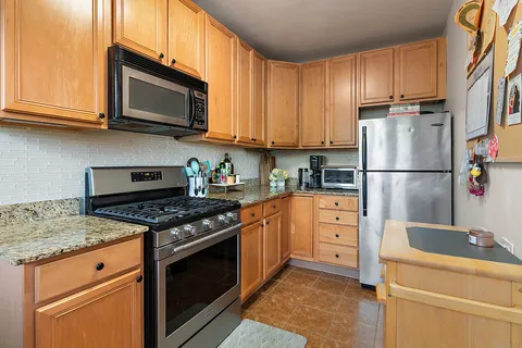a kitchen with granite countertop a sink stove and refrigerator