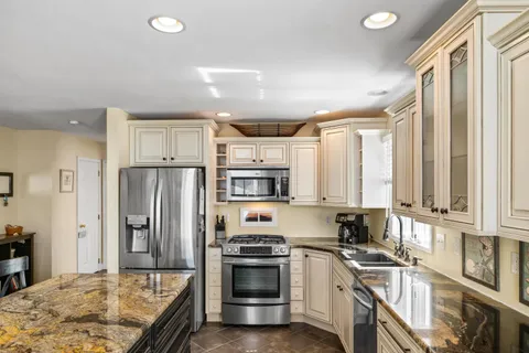 a kitchen with stainless steel appliances granite countertop a stove a refrigerator and a sink