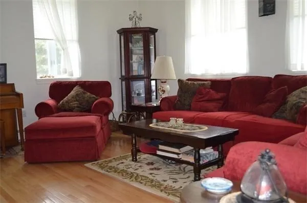 a living room with furniture a wooden floor and a window