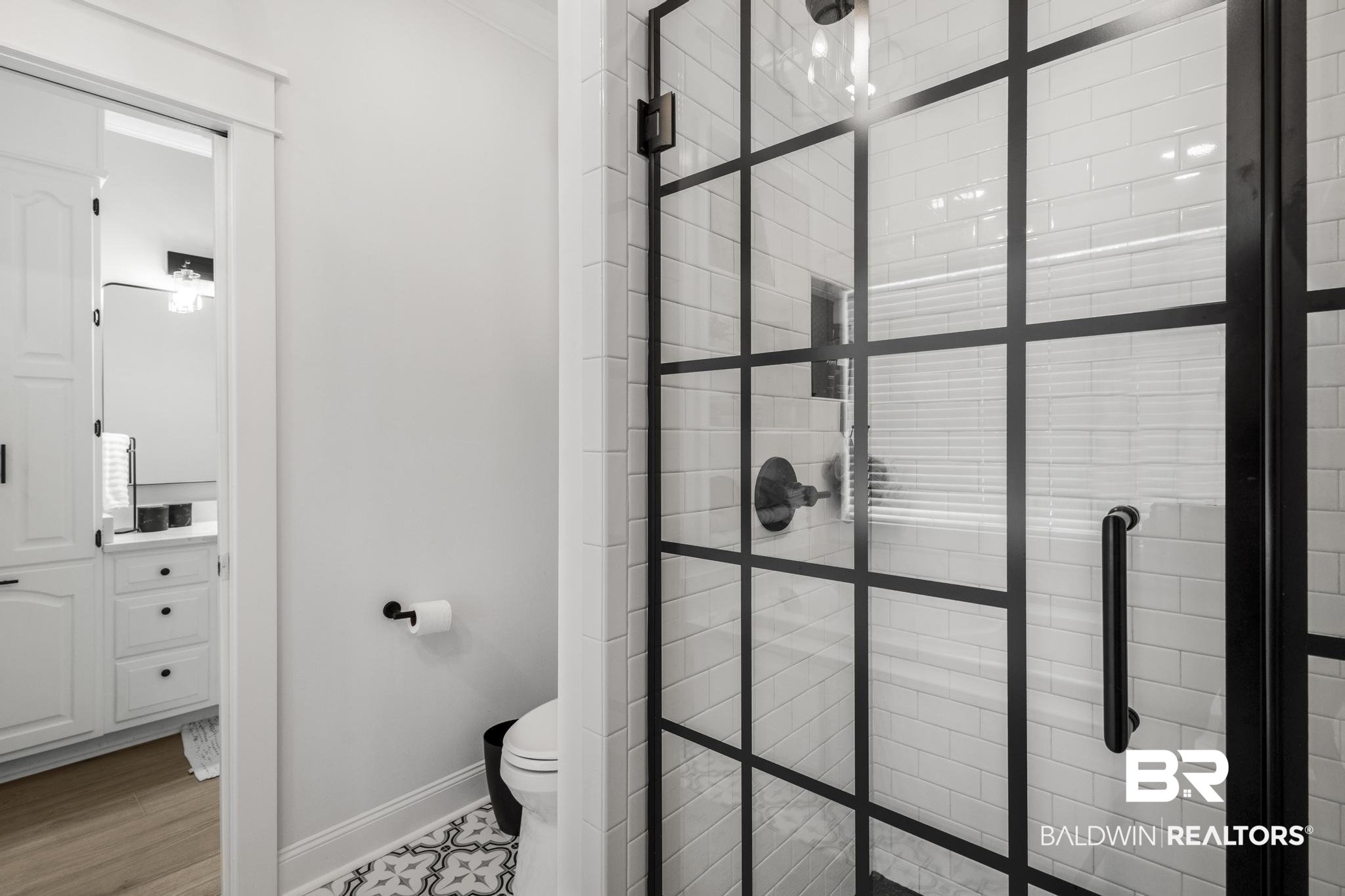 83 Caisson Trace Daphne, AL 36527 - Photo 39 of 63 Contemporary walk-in shower with a black grid-patterned glass enclosure, matte black shower fixtures, and white subway tile surround