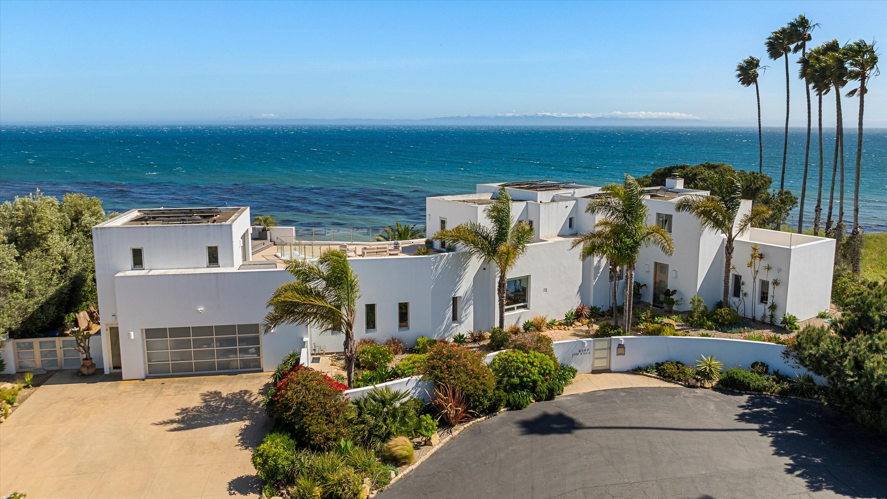 front view of house with a yard and ocean view