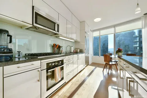 a kitchen with stainless steel appliances granite countertop a stove and white cabinets