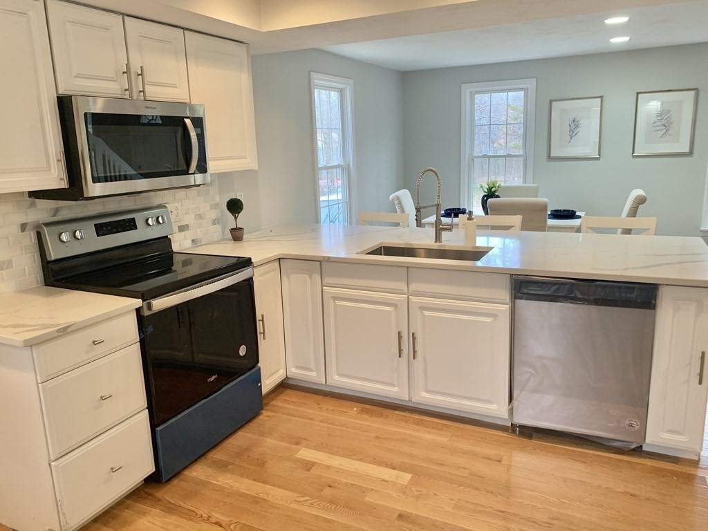 76 Old Douglas Road Webster, MA 01570 - Photo 6 of 22 a kitchen with cabinets stainless steel appliances and wooden floor