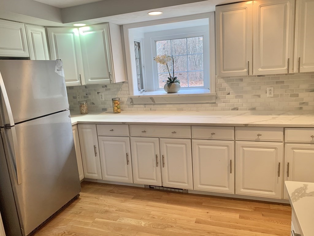 76 Old Douglas Road Webster, MA 01570 - Photo 7 of 22 a kitchen with white cabinets and refrigerator