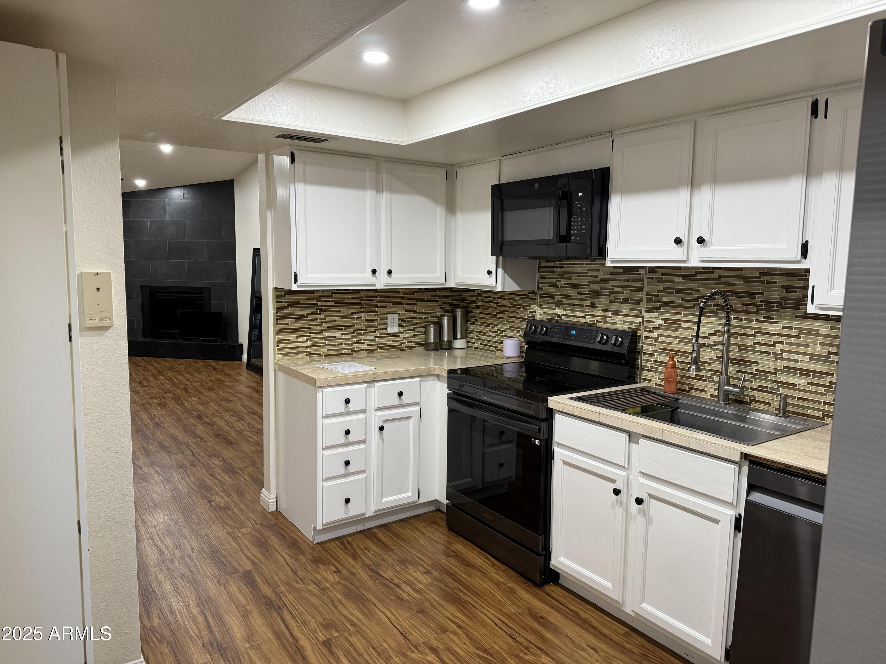 3033 North 37th Street, Unit 12 Phoenix, AZ 85018 - Photo 1 of 11 a kitchen with white cabinets stainless steel appliances and sink