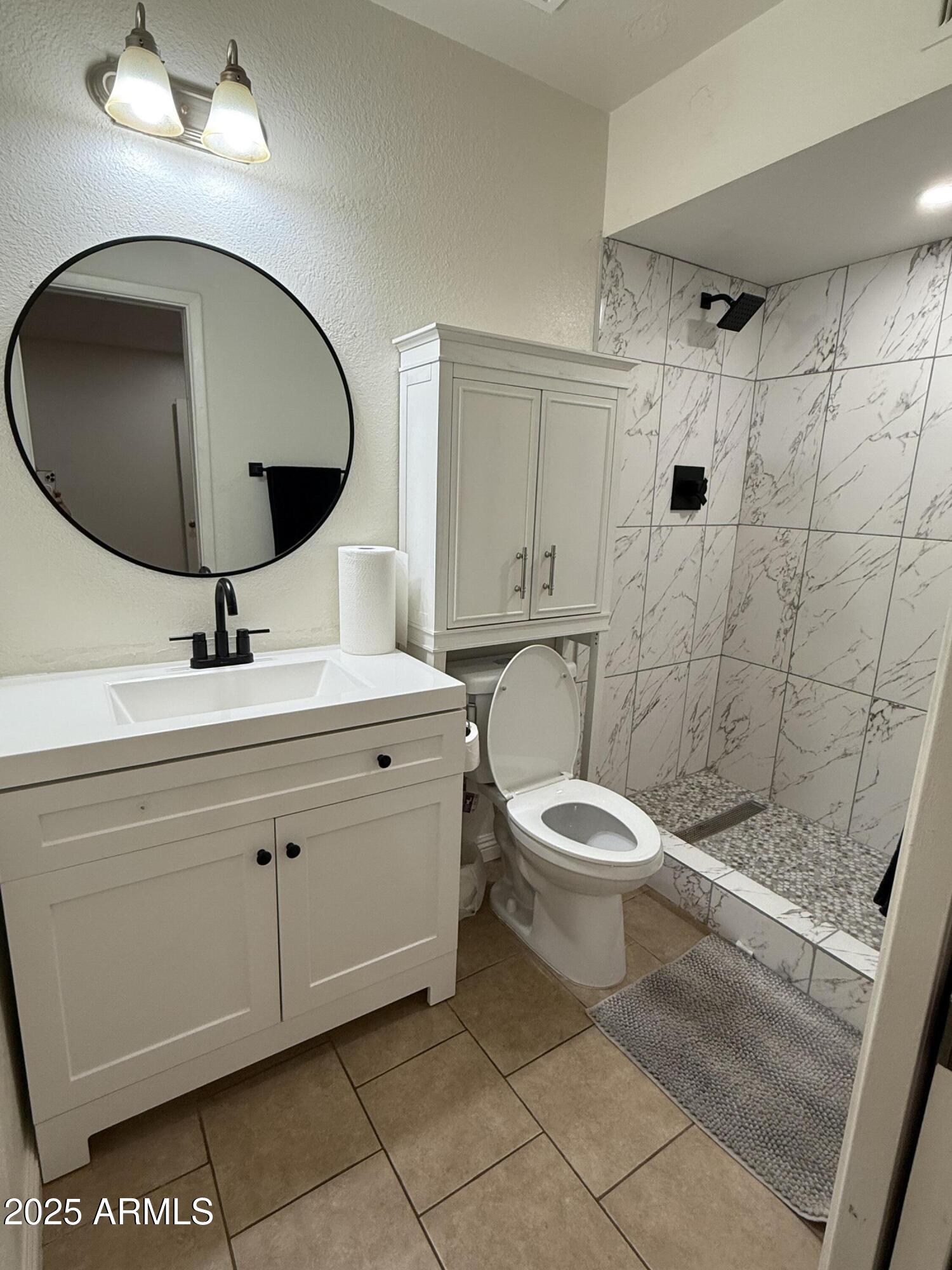 3033 North 37th Street, Unit 12 Phoenix, AZ 85018 - Photo 6 of 11 a bathroom with a toilet a sink and mirror