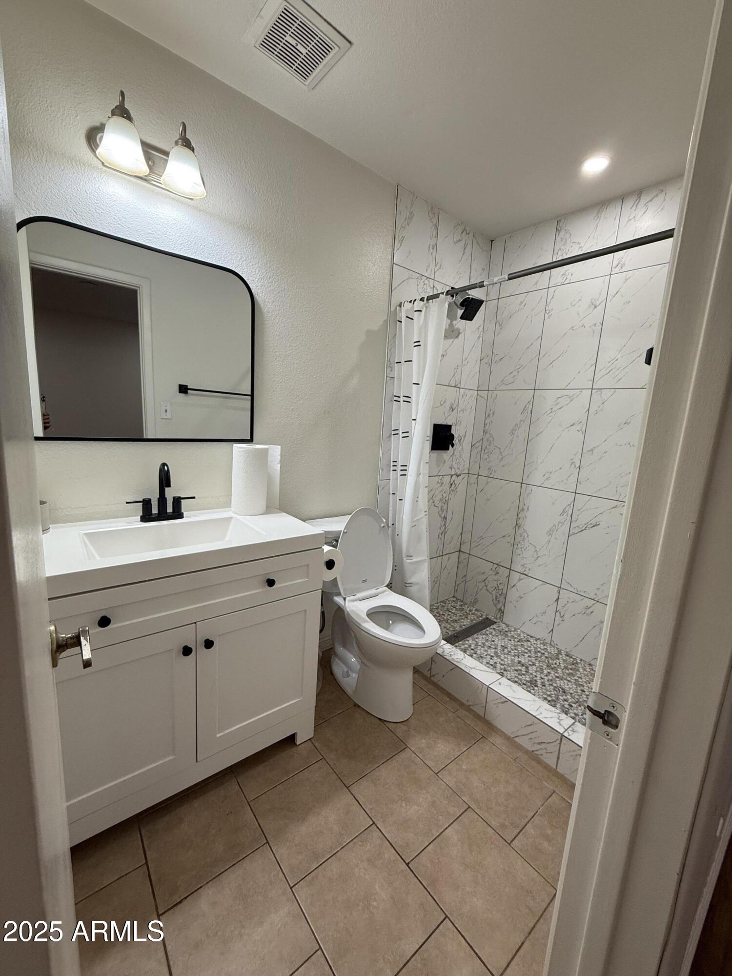 3033 North 37th Street, Unit 12 Phoenix, AZ 85018 - Photo 7 of 11 a bathroom with a double vanity sink mirror and toilet