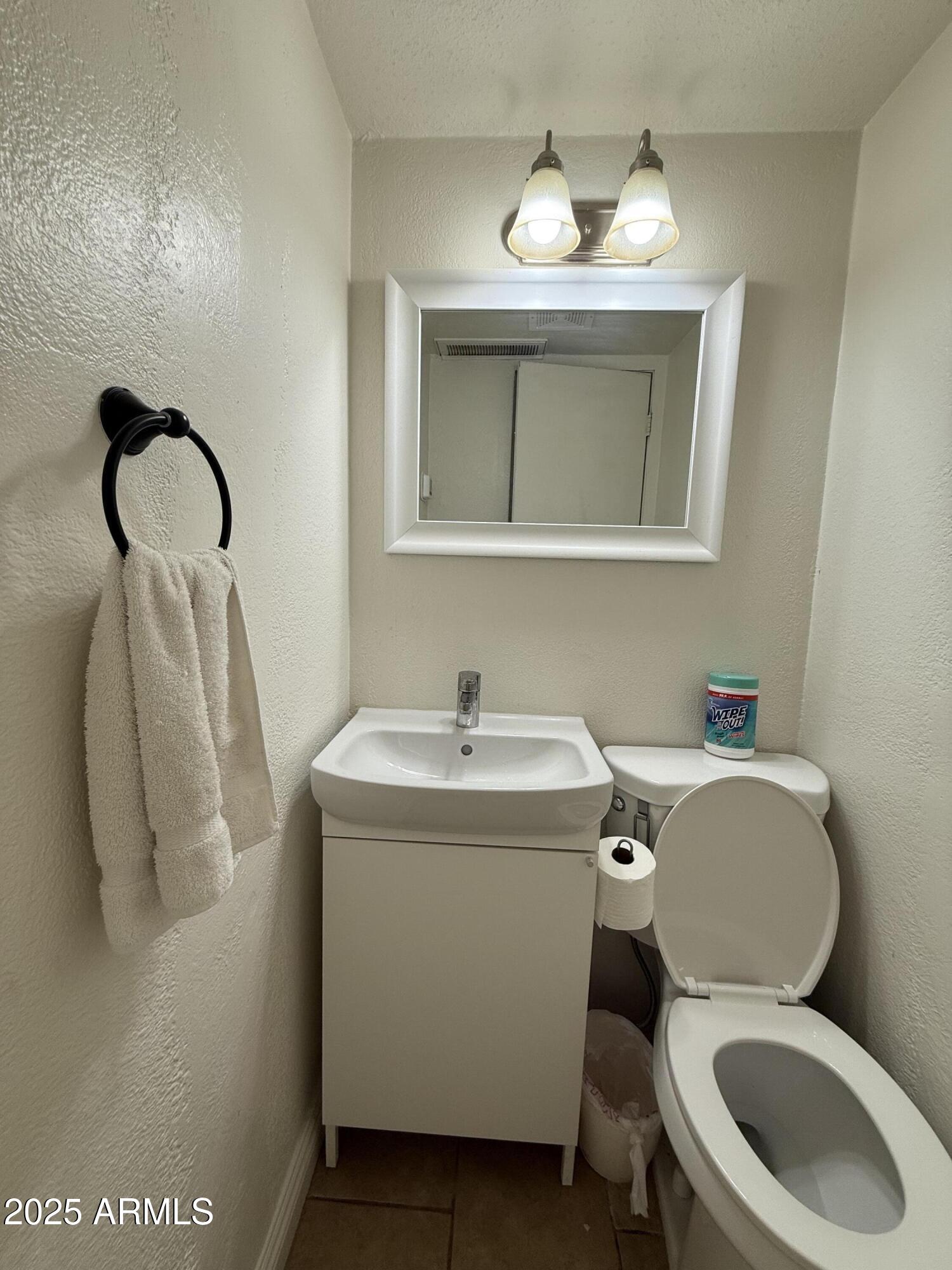 3033 North 37th Street, Unit 12 Phoenix, AZ 85018 - Photo 8 of 11 a bathroom with a toilet sink and mirror