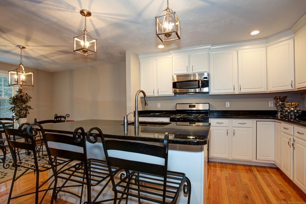 3 C Trail Ridge Way, Unit 7 Harvard, MA 01451 - Photo 15 of 30 a kitchen with stainless steel appliances granite countertop a stove top oven a sink a dining table and chairs with wooden floor