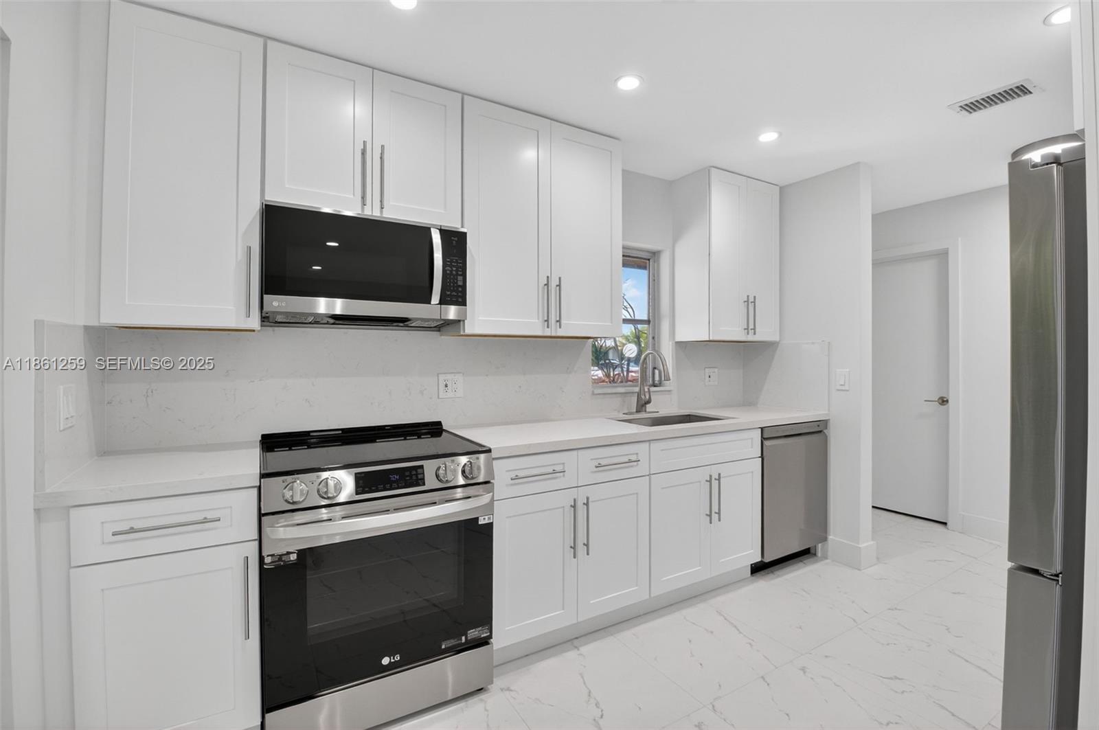 8840 Rheims Road Boca Raton, FL 33496 - Photo 1 of 41 a kitchen with stainless steel appliances granite countertop white cabinets a sink and a stove