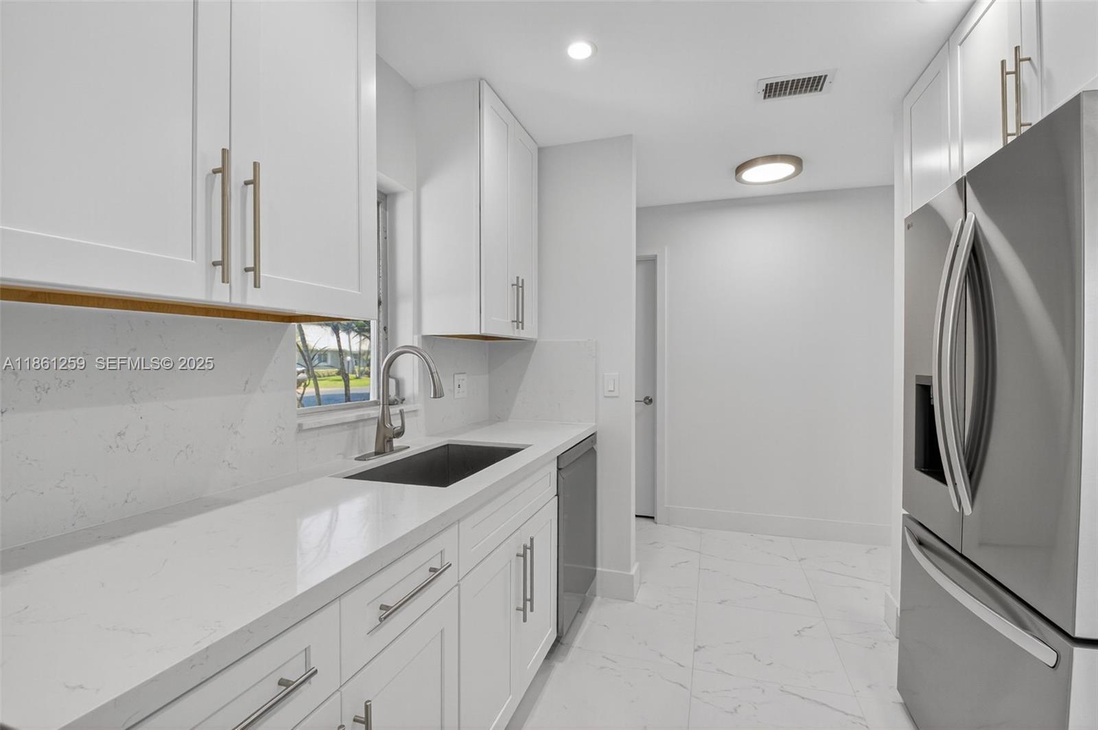 8840 Rheims Road Boca Raton, FL 33496 - Photo 11 of 41 a kitchen with stainless steel appliances granite countertop a refrigerator and a sink