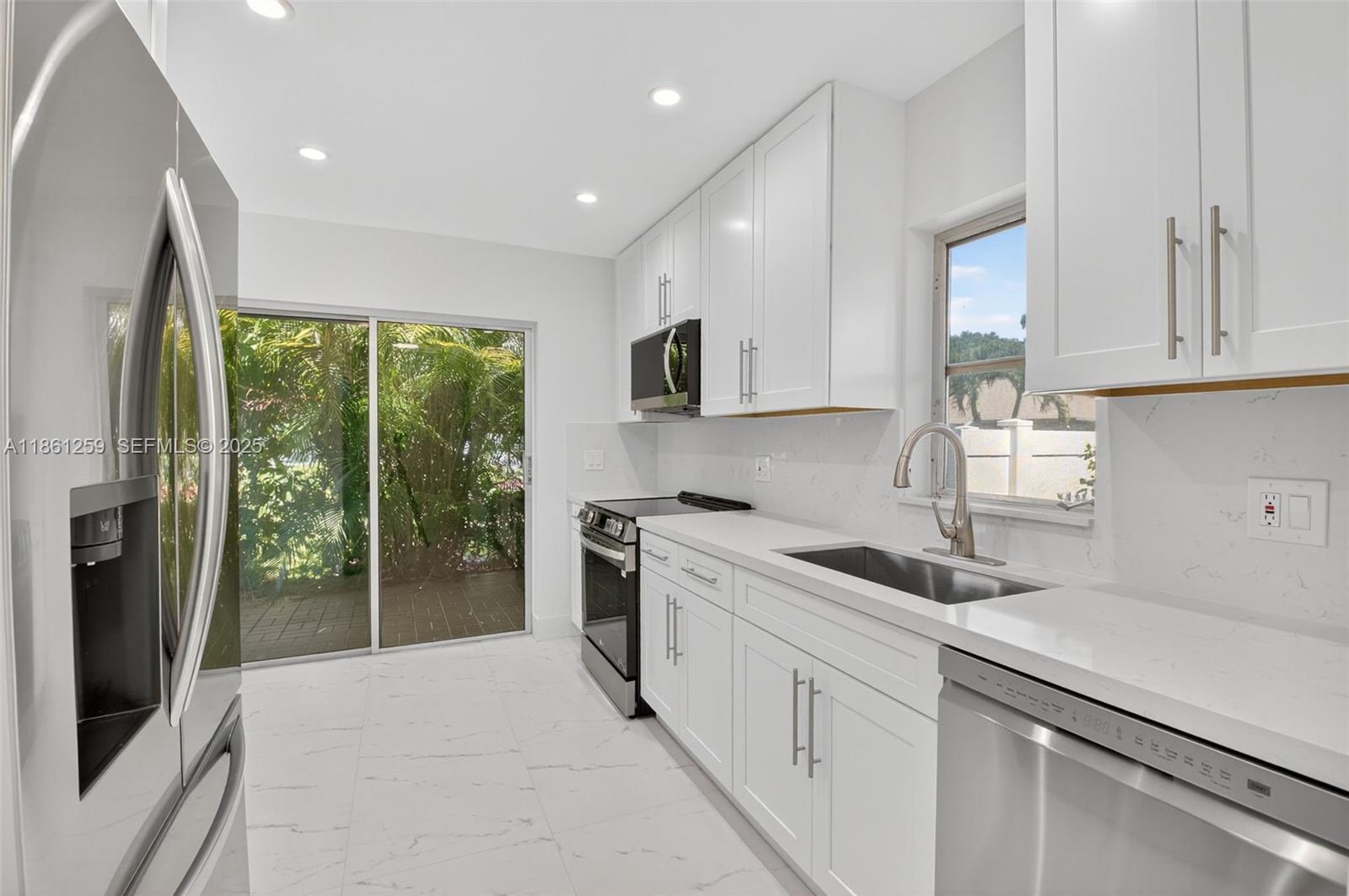 8840 Rheims Road Boca Raton, FL 33496 - Photo 12 of 41 a kitchen with a sink stove and cabinets