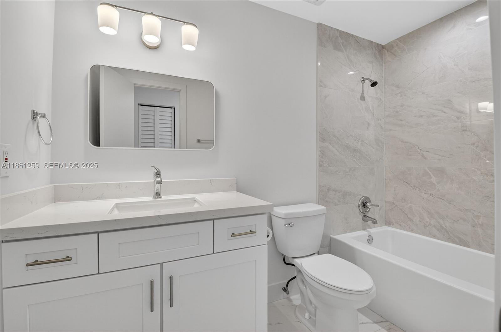 8840 Rheims Road Boca Raton, FL 33496 - Photo 15 of 41 a bathroom with a toilet a sink a mirror and vanity
